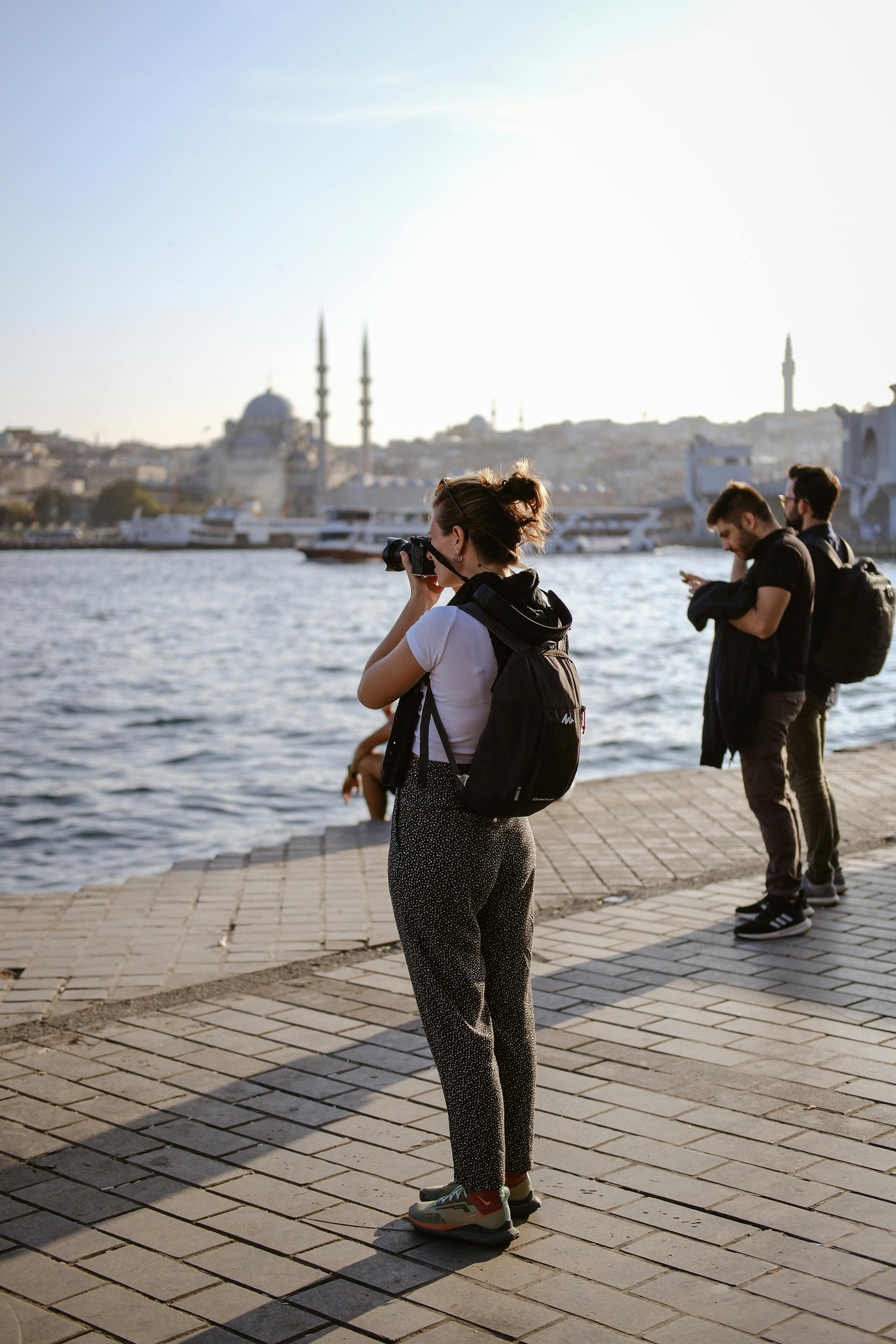 a woman taking pictures of the water and people