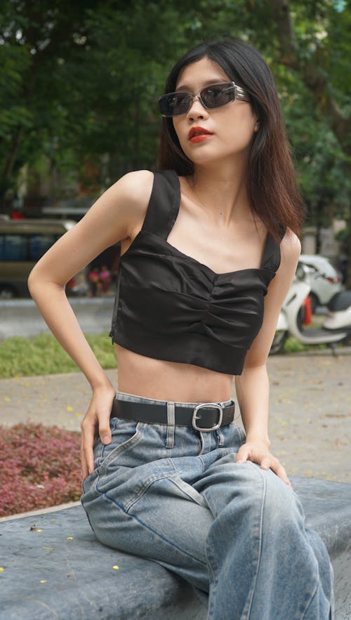 Model in Sunglasses Sitting in Park