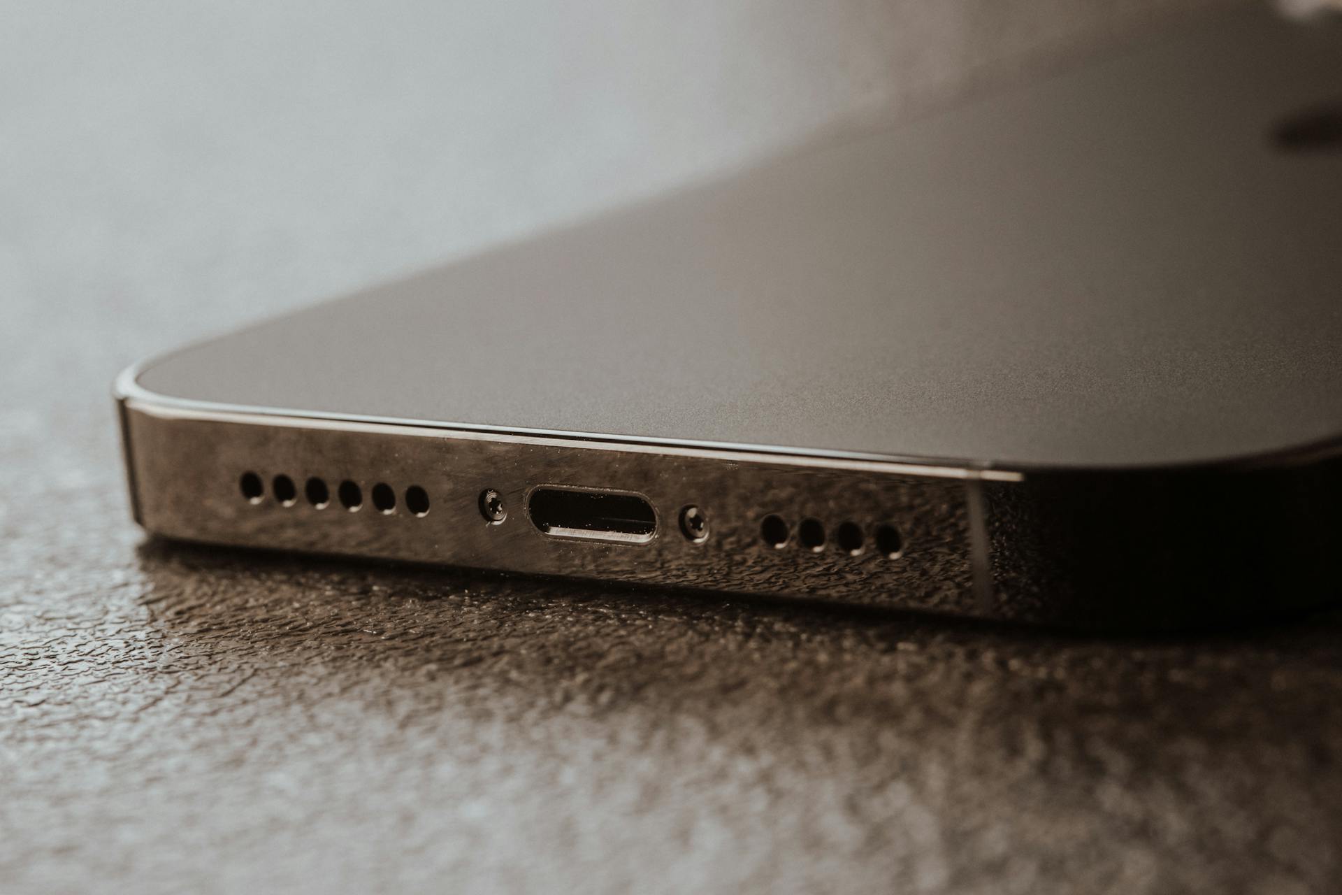 A detailed close-up of a smartphone charging port on a textured surface.