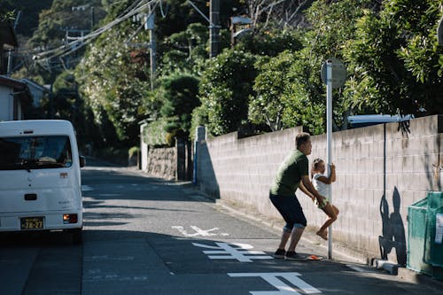 Father Helping Daughter Climbing Road Sign