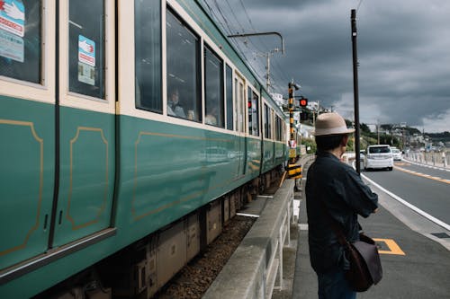 Man Waiting on Sidewalk in front of Passing Train