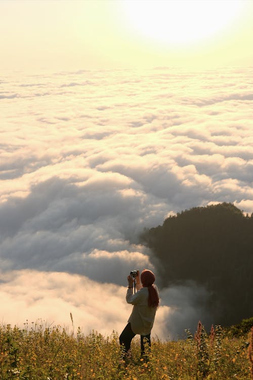 Woman in a Mountain Valley Covered with Clouds