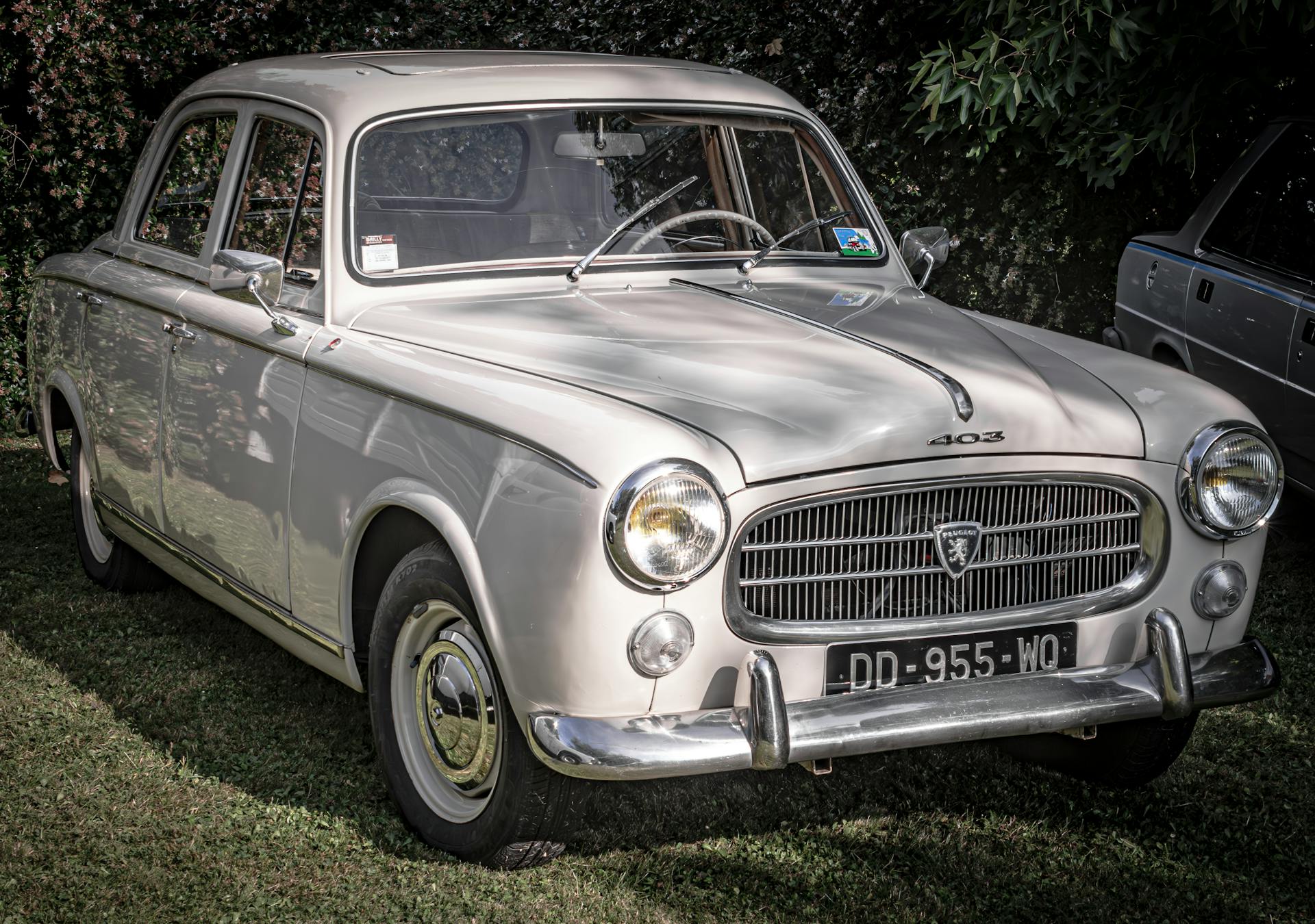 Vintage Peugeot 403 sedan parked on grass, showcasing its classic design.