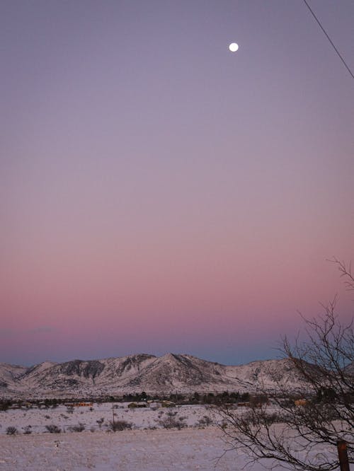 Full Moon over Snowy Landscape at Dawn