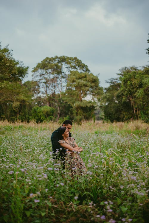 A Couple Hugging on a Grass Field 