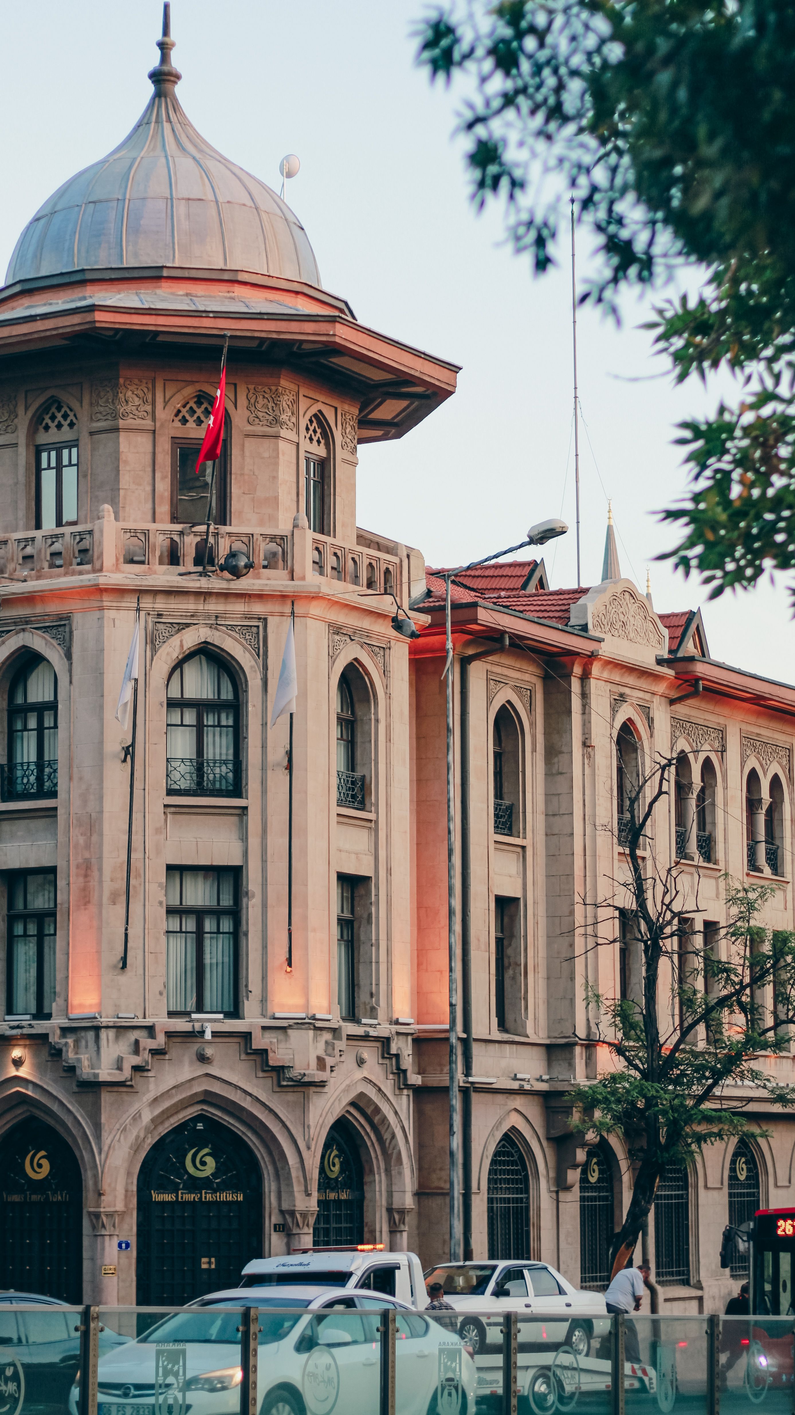 Classical architectural facade in Ankara, Turkey, during evening light with visible Turkish flag.