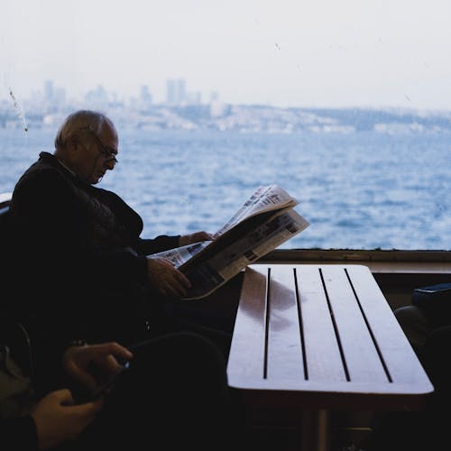 Man Reading Newspaper on Ferry