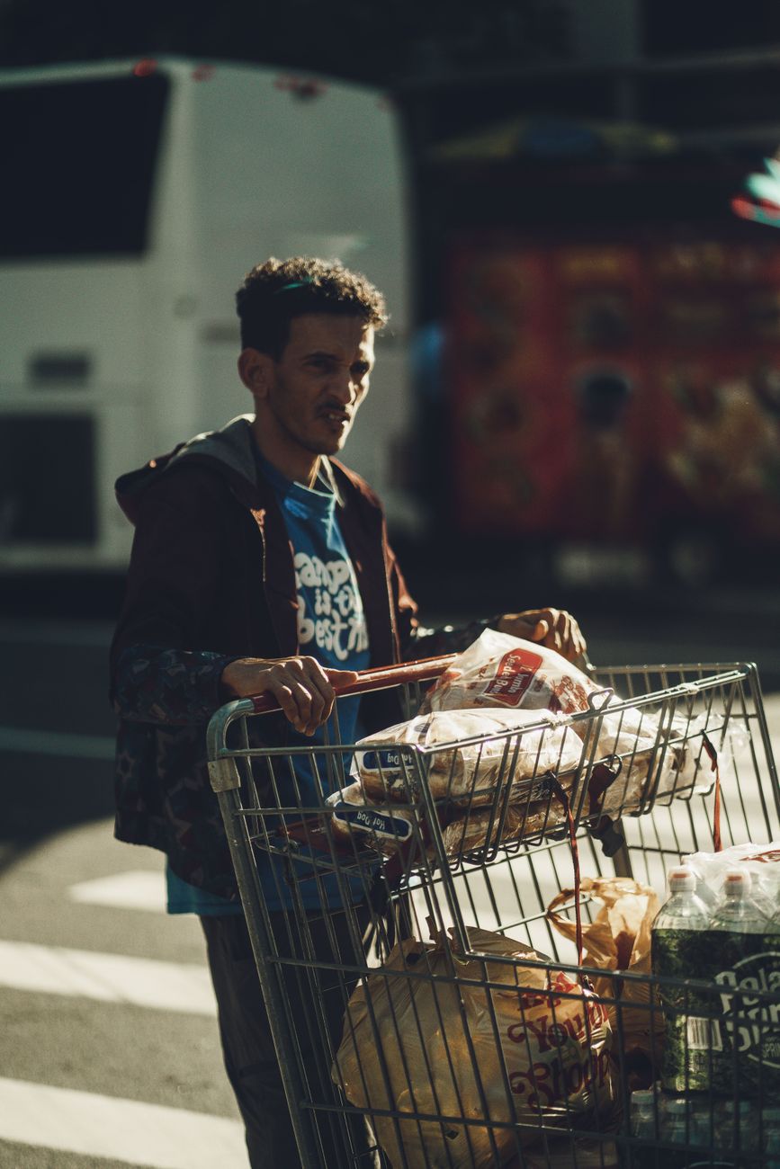 Shoppers fill a grocery cart on a city street as inflation keeps pressure on household budgets.