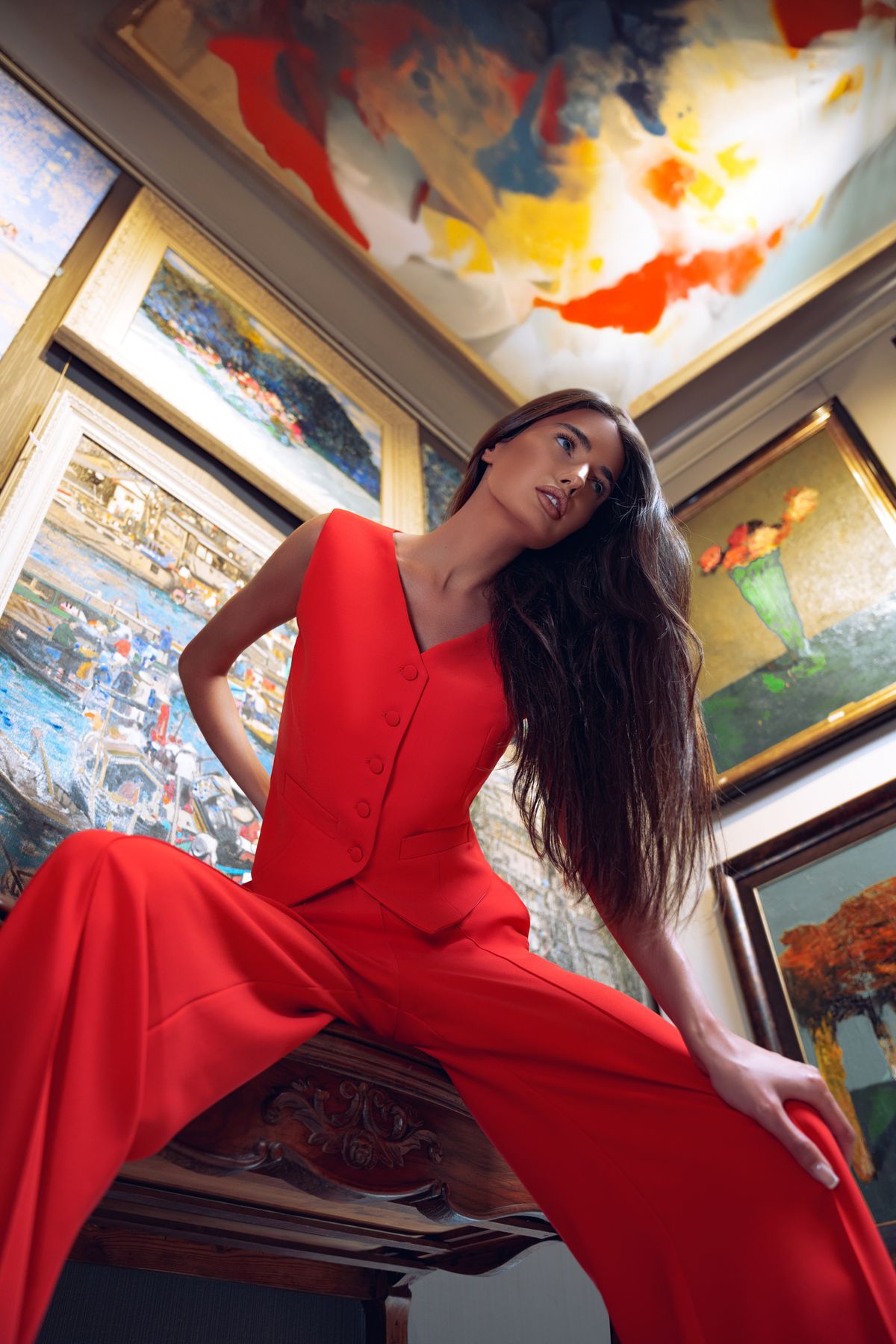 A woman posing in red in an art gallery, low angle — the drama of the occasion red