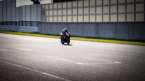 Free Rider on a motorcycle racing at high speed on a tarmac racetrack. Stock Photo