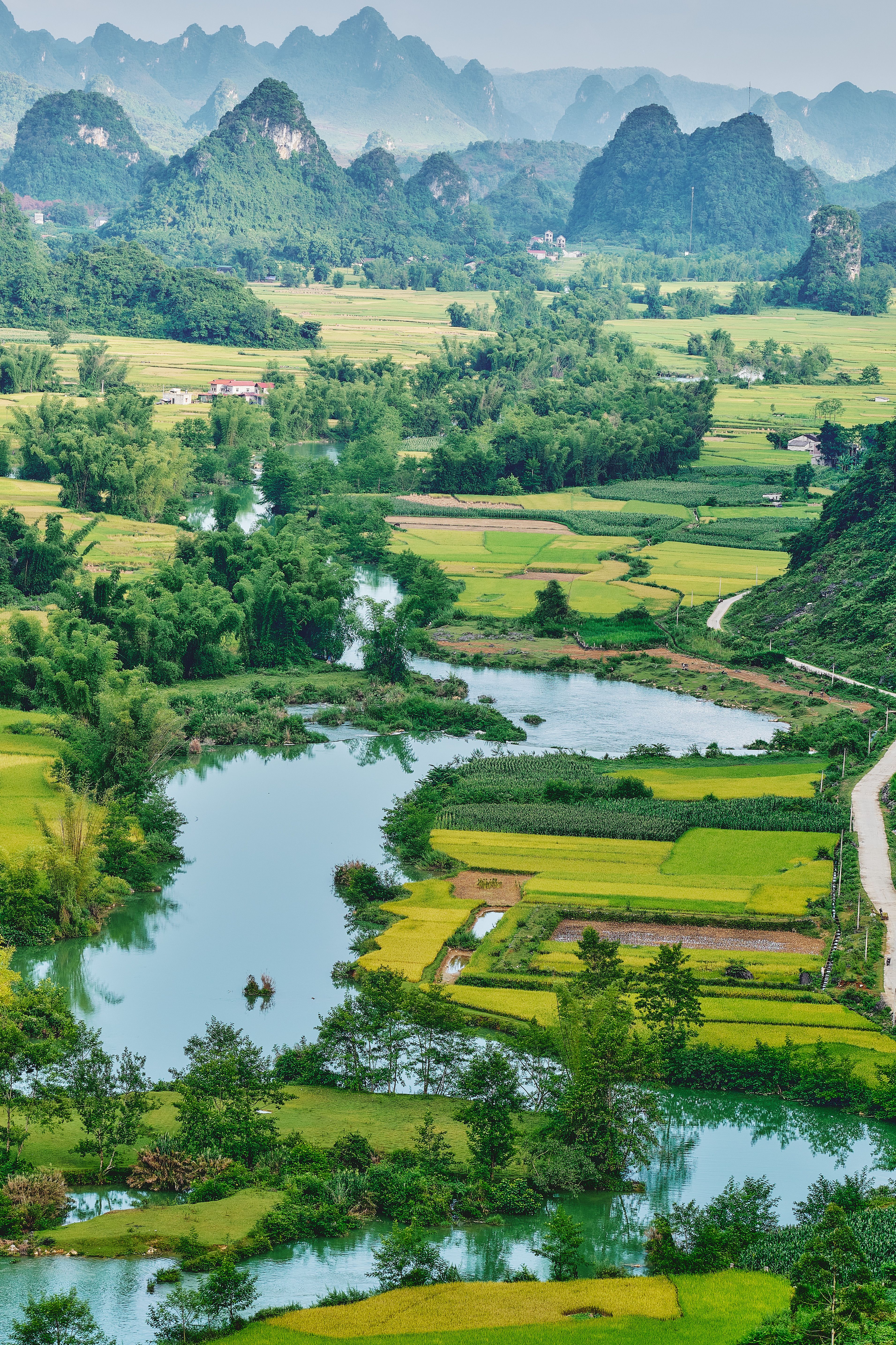 Stunning aerial view of Vietnamese countryside with lush fields and mountains.