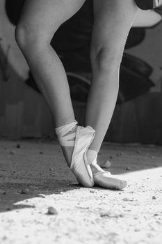 Black and white photo of a ballet dancer posing gracefully on pointe shoes.