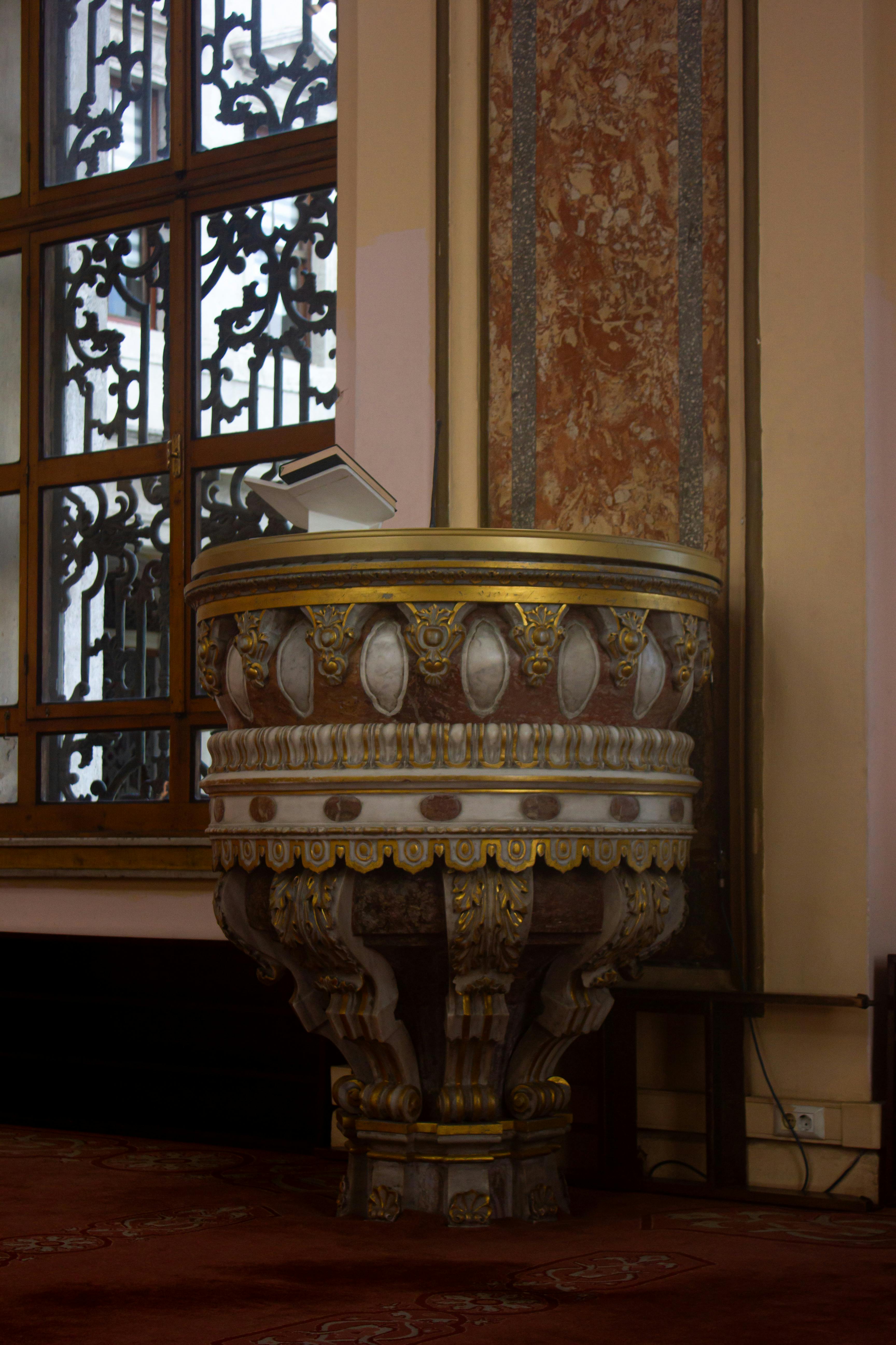 Intricate church pulpit adorned with gold detail, showcasing traditional architecture.