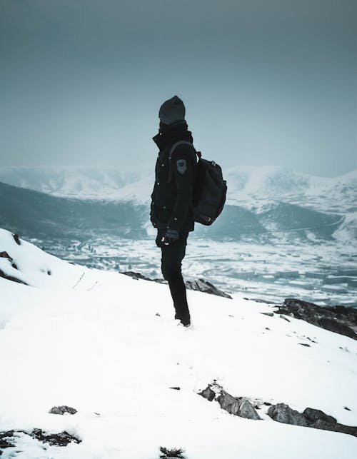 Persona In Piedi Sulla Montagna Ricoperta Di Neve