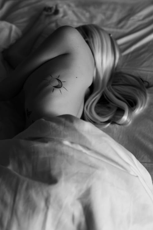 Blonde Woman Lying in Bed in Black and White