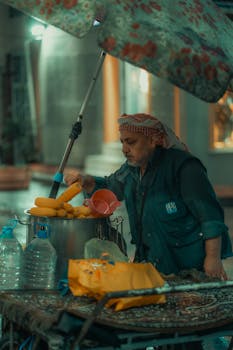Street vendor preparing corn on the cob at a market in Bursa, Turkey at night.