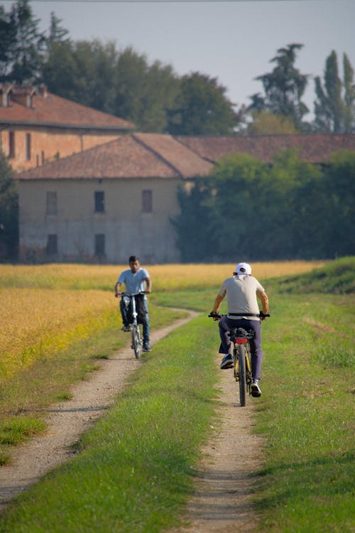 Kostnadsfri bild av cyklister, grusväg, landsbygden