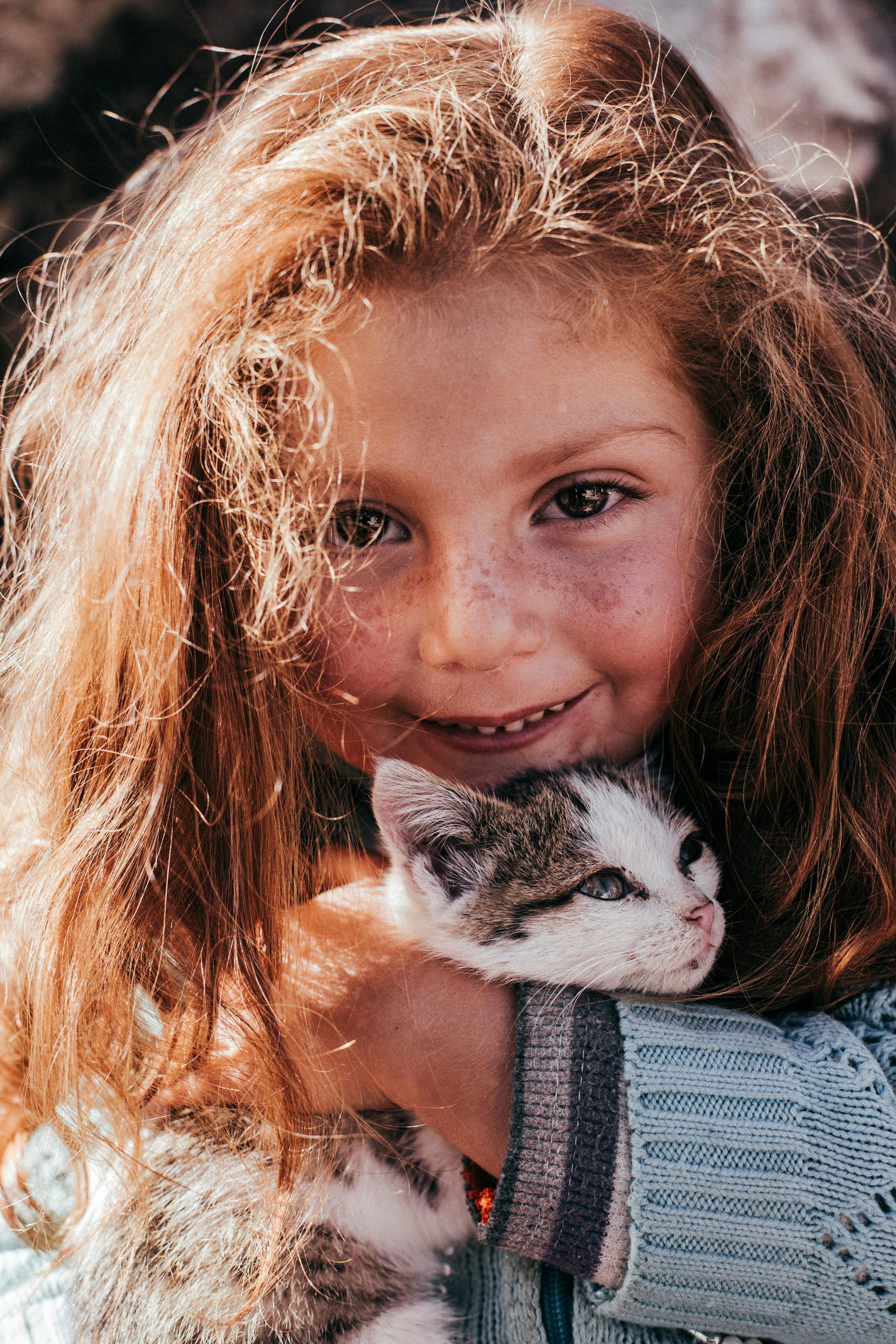 a little girl hugging a cat