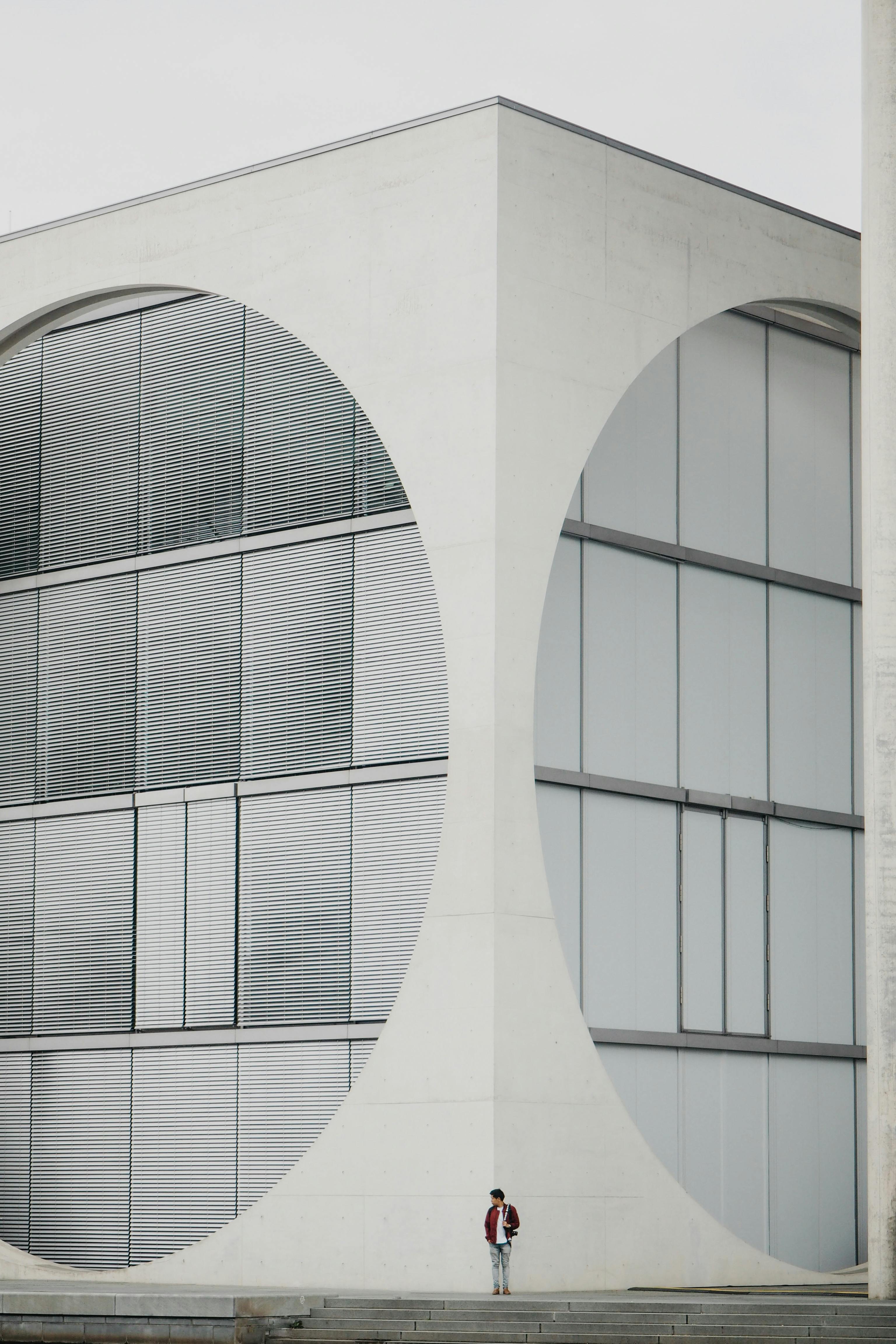 person standing near corner of white modern building