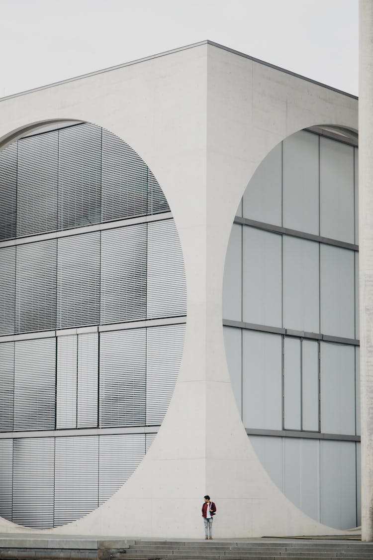 Person Standing Near Corner Of White, Modern Building