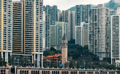 Free A bustling urban skyline showcasing modern skyscrapers surrounding a historic clock tower. Stock Photo