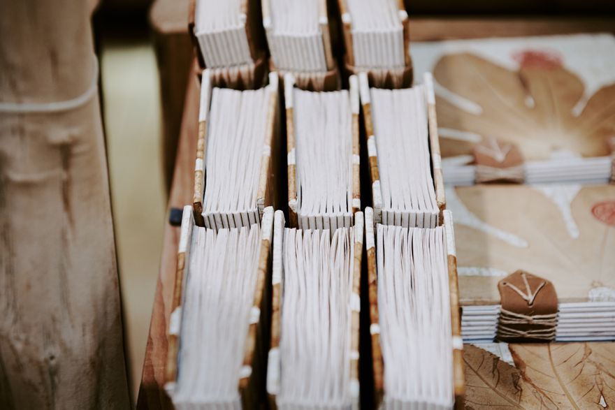 Hand-sewn notebooks laid out on a bindery bench — photo by Suki Lee on Pexels
