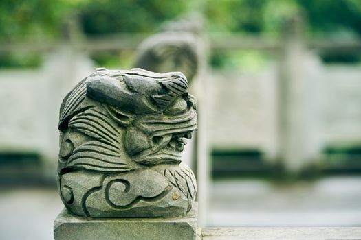 Detailed carved dragon head sculpture on a post, showcasing ornate art and craftsmanship.