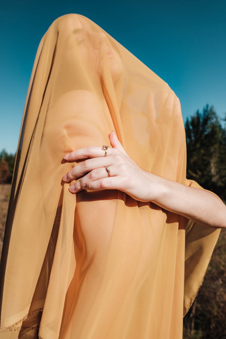 Woman Covered In Yellow Sheer Fabric Posing Outside 