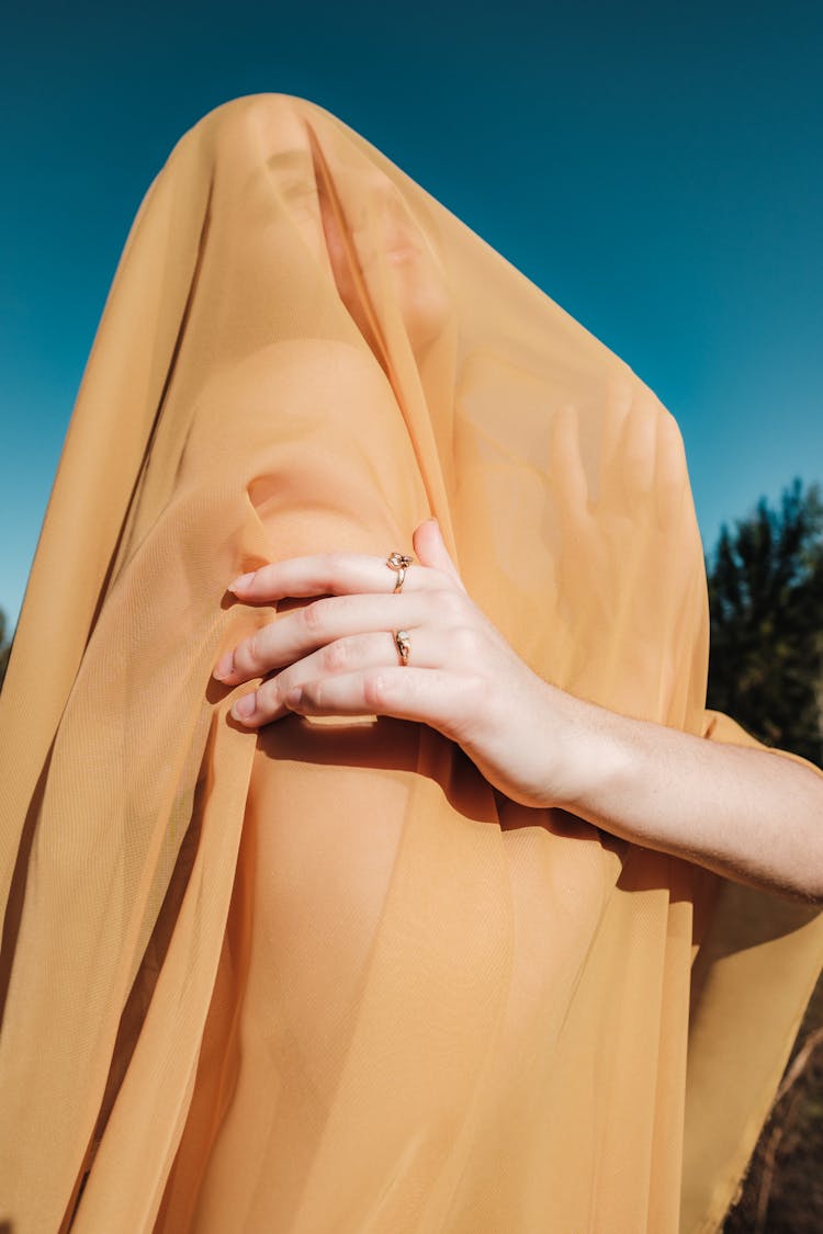 Woman Covered In Yellow Sheer Fabric Posing Outside 