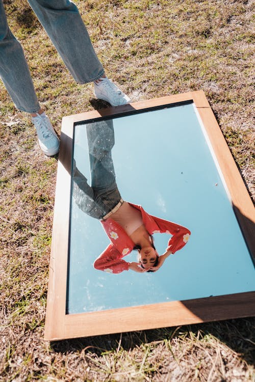 Reflection of a Woman in a Mirror Lying on the Ground 