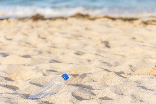Empty Plastic Bottle Buried in Sand