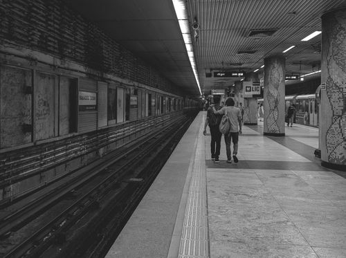 Free Couple walking on Kolkata metro platform, black and white urban scene. Stock Photo