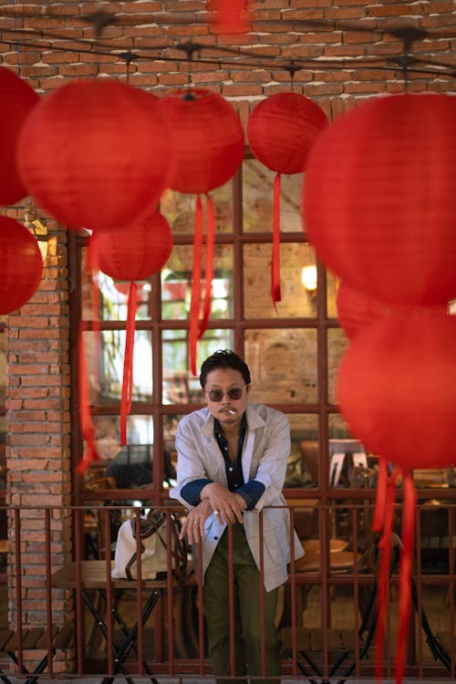 Portrait of a Man Standing on a Balcony under Red Chinese Lanterns