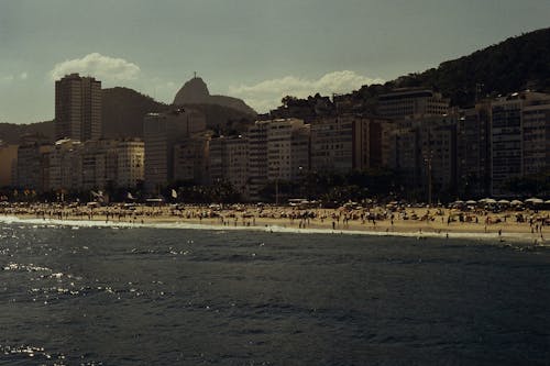 People on Beach Near Buildings