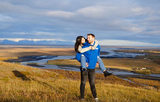 Loving couple embracing with scenic views in Kirkjubæjarklaustur, Iceland.