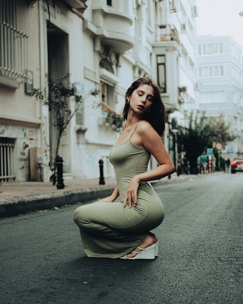 Model in Green Dress Squatting on Street