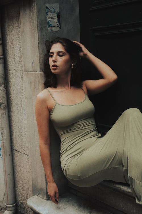 Model in Green Dress Sitting on Wall