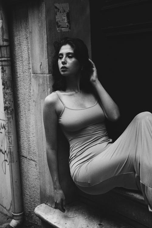 Model in Dress Sitting on Wall in Black and White