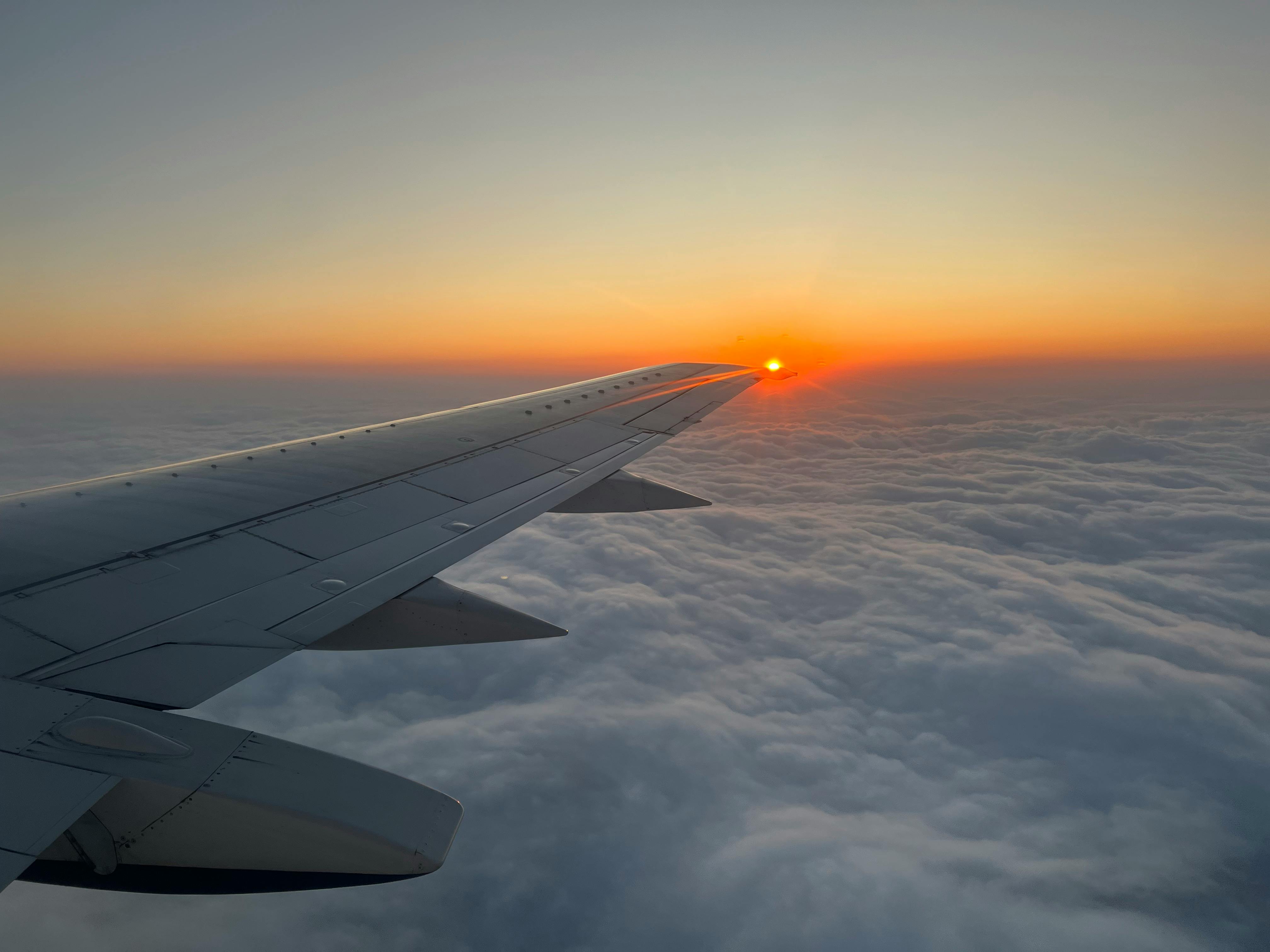 Wing of an Airplane Flying over a Thick Fog at Sunrise · Free Stock Photo