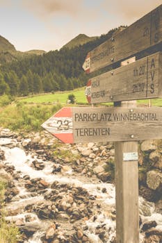 在意大利泰伦托，一条河流附近的乡村路标，背景是郁郁葱葱的山脉