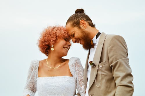 A bride and groom are smiling at each other