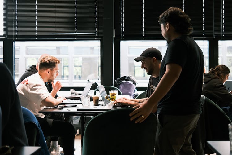 Smiling Men Working On Laptops On Table