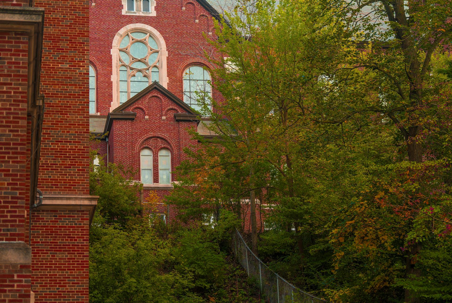 A traditional brick building in Wisconsin surrounded by lush green trees, capturing architectural charm.