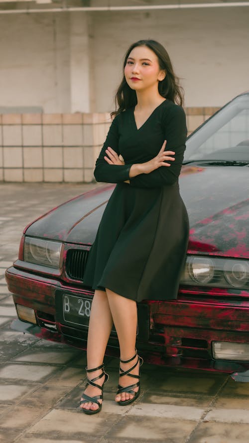 Model in Black Dress Standing by Car