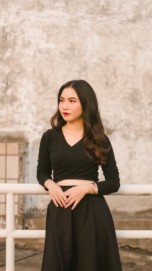 Young Woman in a Black Outfit Posing Outside 