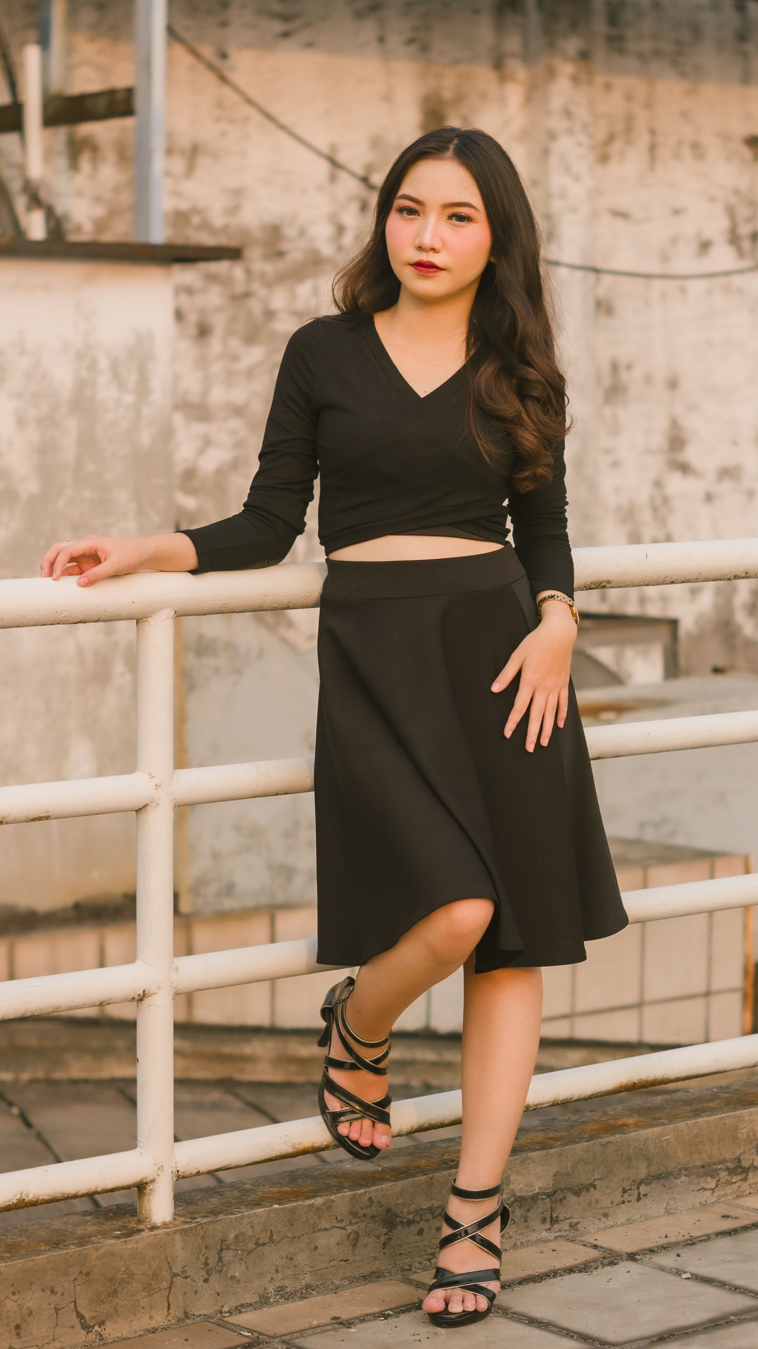 Person Leaning on Railing Posing Outdoors · Free Stock Photo
