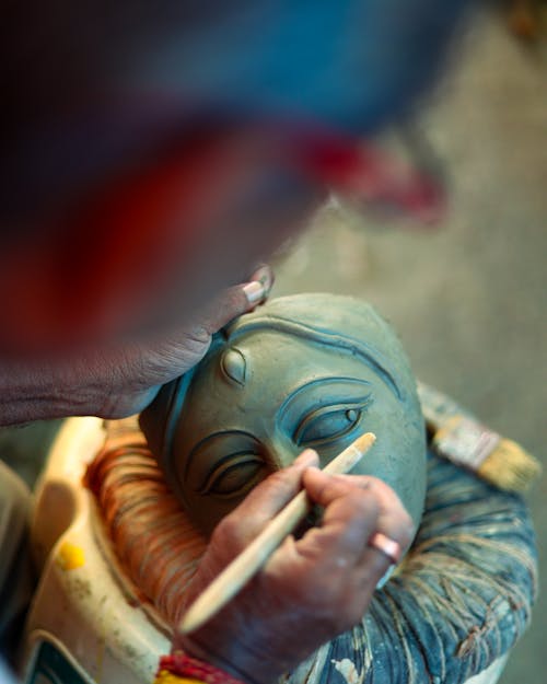 Man Painting a Buddha Statue 