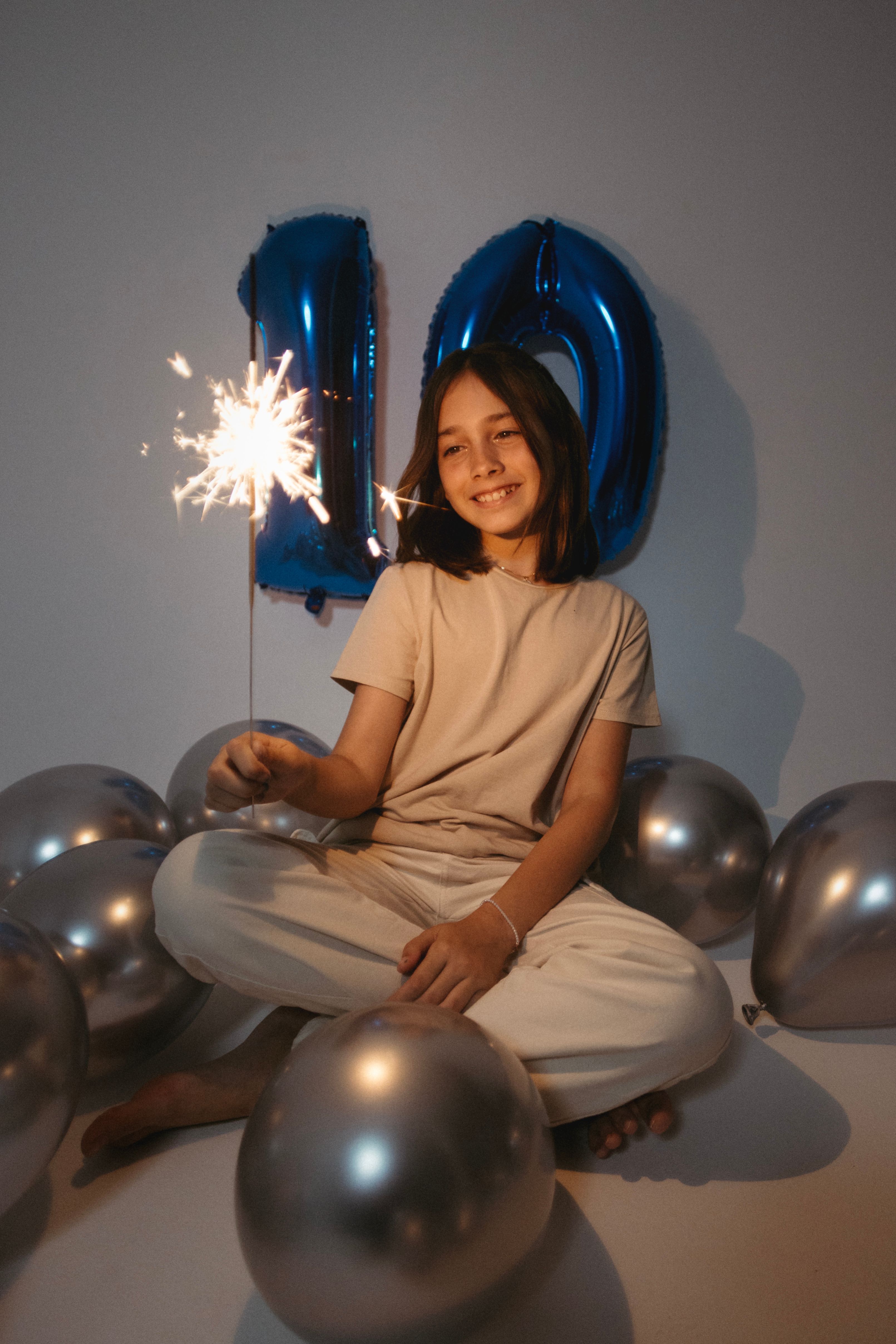 A woman sitting on the ground with sparklers and balloons · Free Stock ...