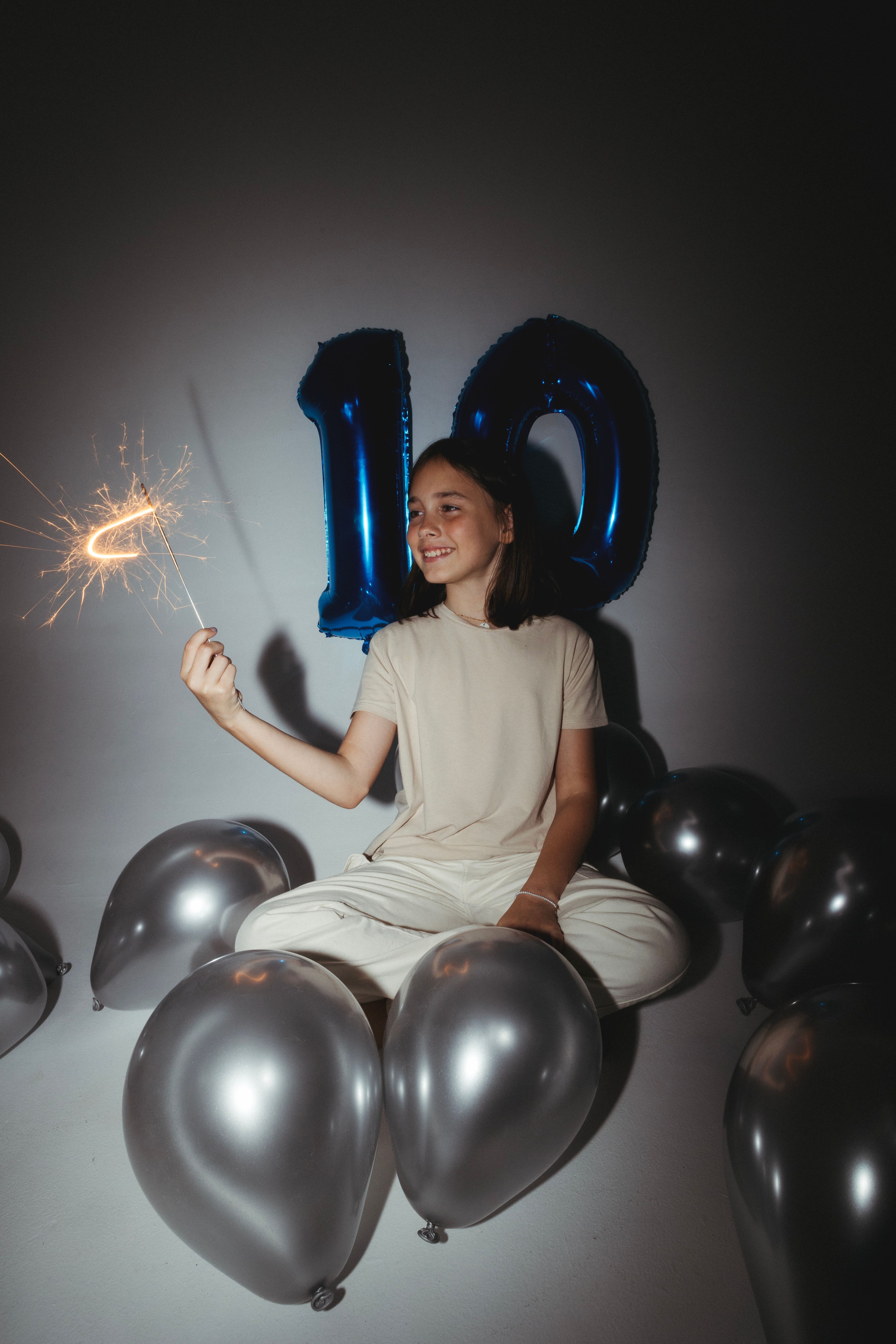 A woman sitting on the ground with sparklers and balloons · Free Stock ...