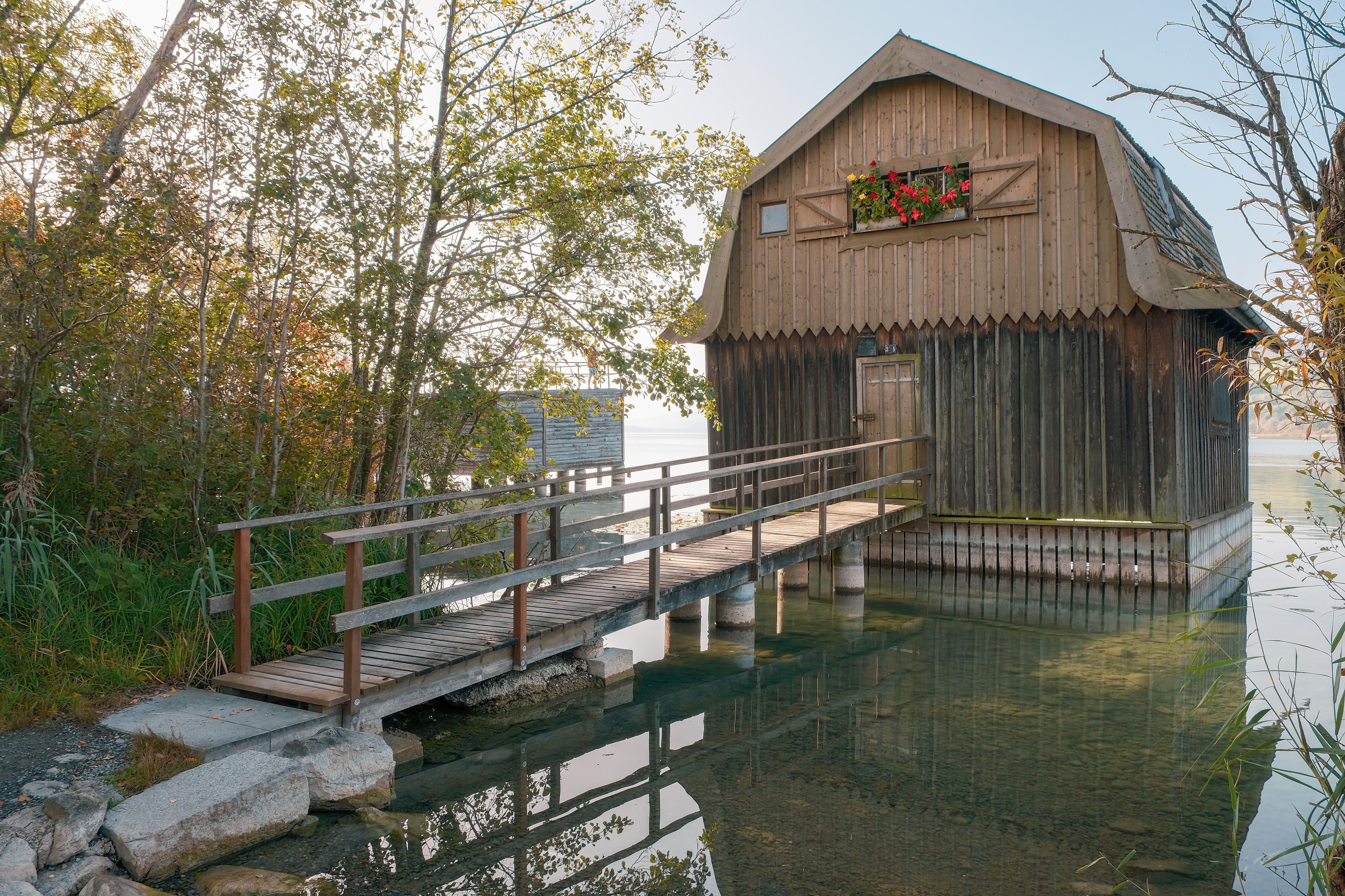 A wooden house with a bridge over a lake · Free Stock Photo